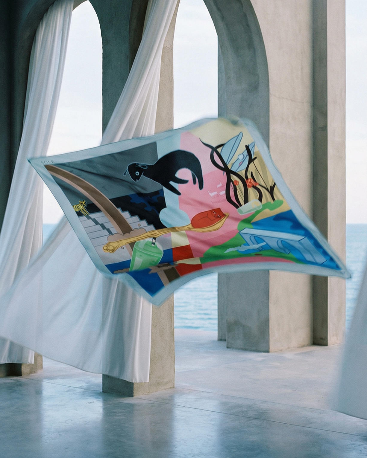 Colorful scarf floating in a modern architectural setting with large arches and white drapes.