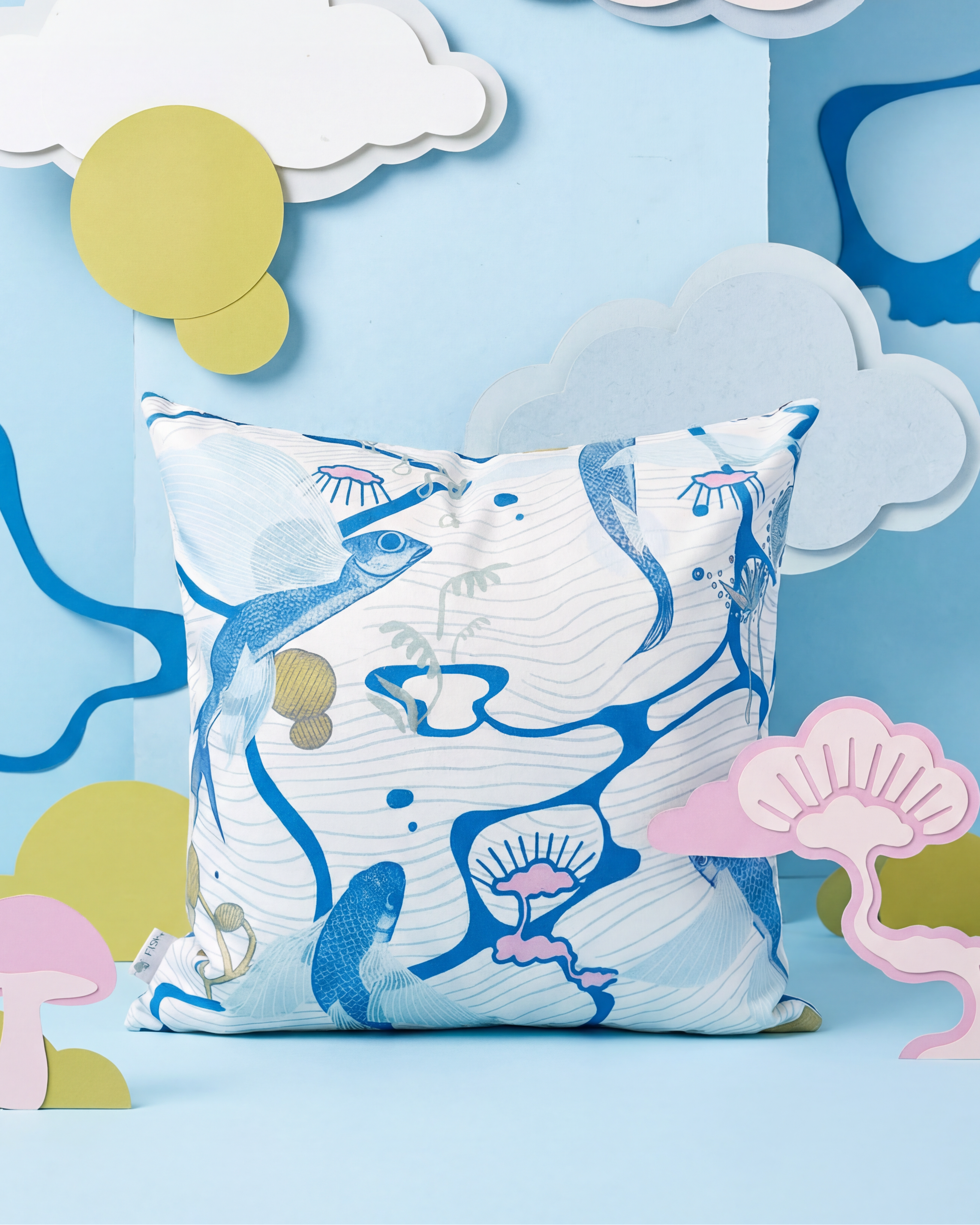 Decorative pillow with mermaid design on a blue background with clouds and sun